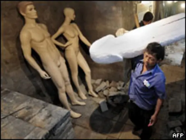 Рабочий с макетом мужского члена