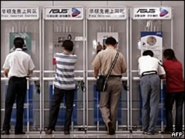 Пассажиры в аэропорту Пекина у стойки доступа к бесплатному интернету