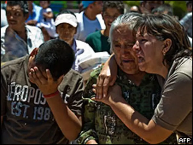 Familiares de una víctima lloran en el cementerio.