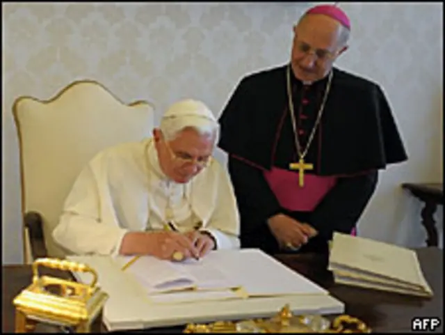 Бенедикт XVI (слева) подписывает свою энциклику