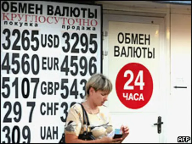 Женщина стоит возле пункта обмена валют в Москве 13 июля