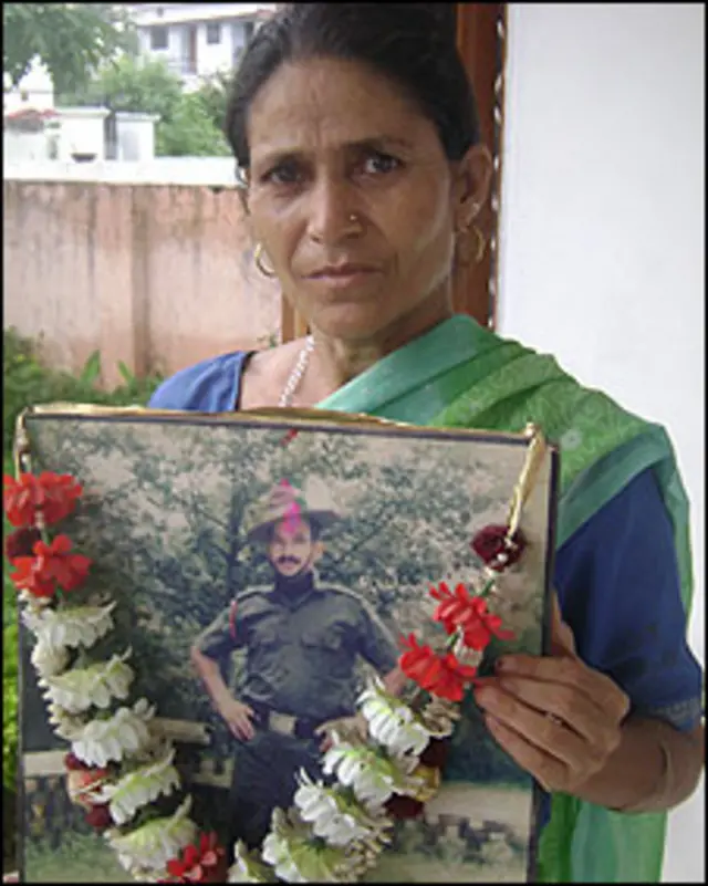 मुन्नी देवी अपने पति की तस्वीर के साथ