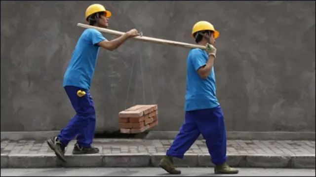 Hai lao động đang gánh gạch tại Bắc Kinh (AP)