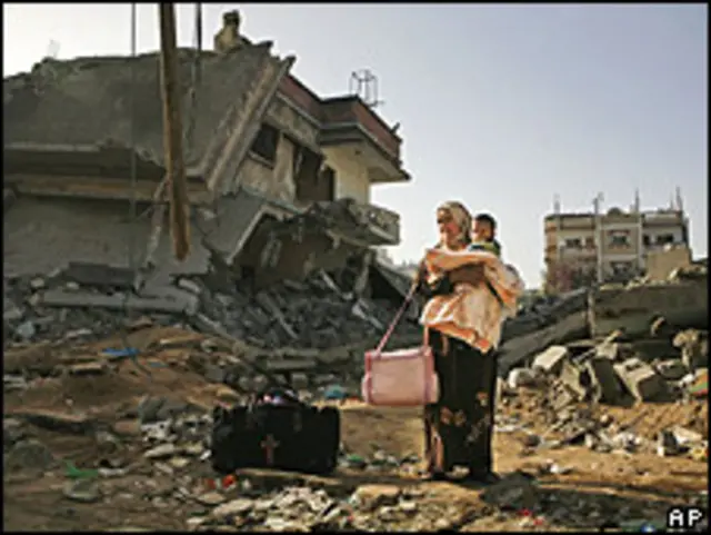 Mujer palestina con su bebé en medio de las ruinas