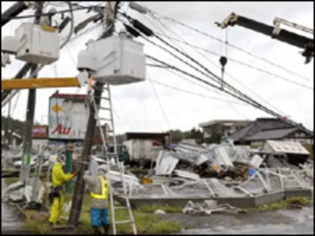 Trabalhadores consertam sistema de luz em Tsuchuira após passagem do tufão Melor (08/10/09)