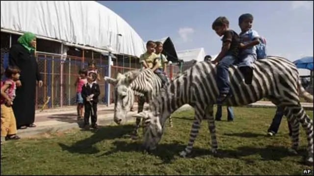 کودکان غزه به بازی با خرهای رنگ شده به شکل گورخر مشغولند