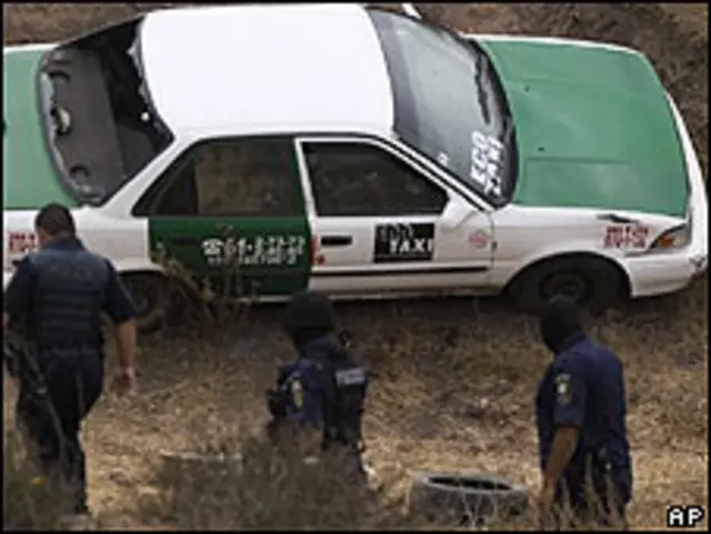 Policías cerca de un vehículo involucrado en un intercambio de disparos entre presuntos narcotraficantes