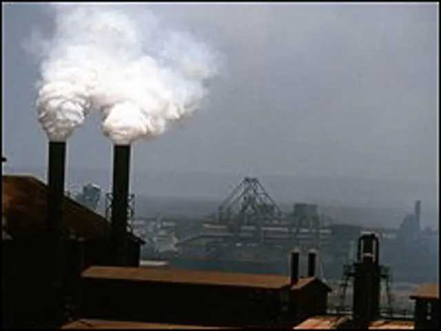 Труба выбрасывает дым в небо