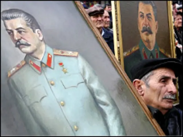 Пожилой человек и портреты Сталина