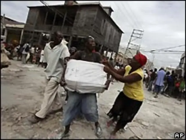 Haitianos peleando por paquetes de ayuda
