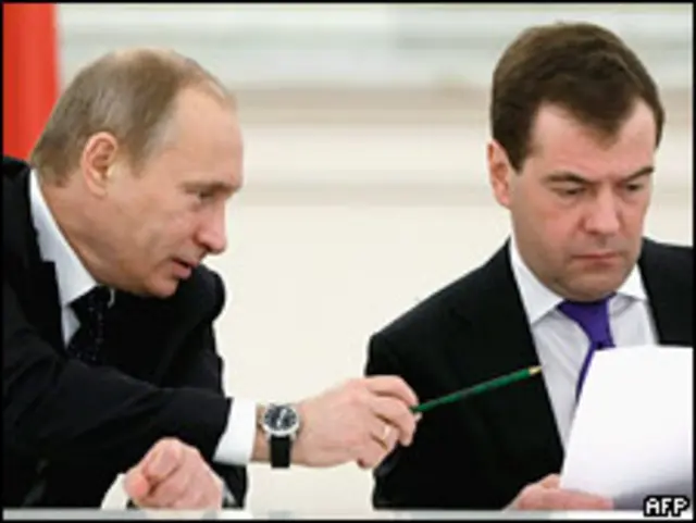 Владимир Путин подает лист бумаги президенту Дмитрию Медведеву на заседании Госсовета в Кремле 22 января 2010 года