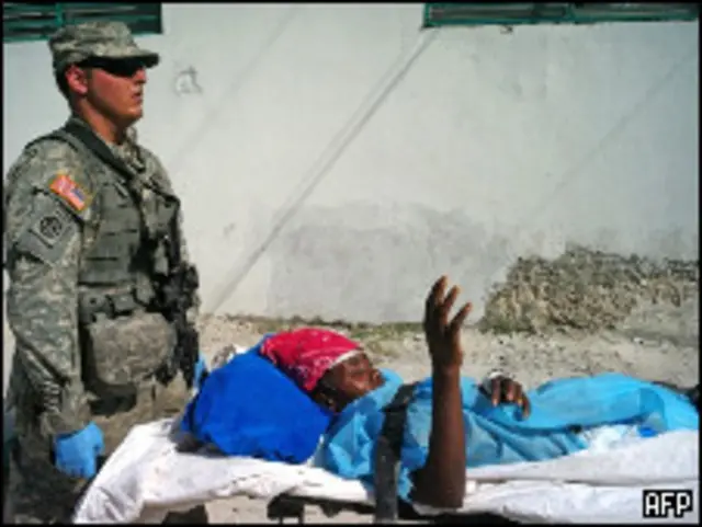 Vítima do terremoto é carregada em maca no Haiti