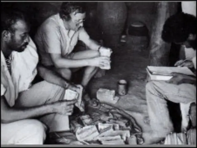 Эфиопский повстанец в одежде продавца зерна получает деньги