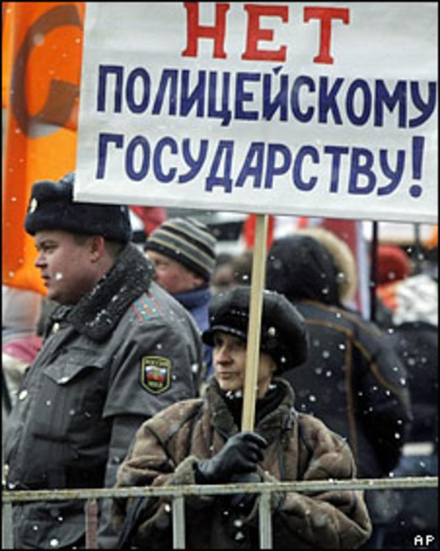 Женщина на митинге с требованием реформ МВД держит плакат "Нет полицейскому государству!"