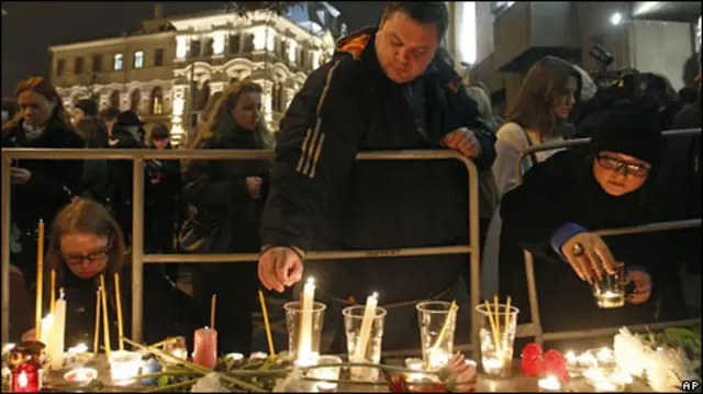 Люди зажигают свечи в память о жертвах взрывов