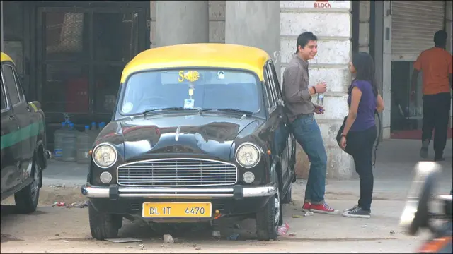 印度新德里康诺特广场附近一对年轻男女在出租车旁聊天（12/3/2010）