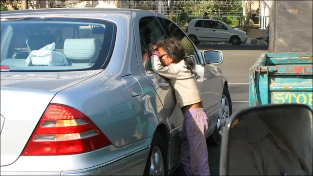 印度新德里街头一名女孩正向停车等候交通灯的奔驰轿车讨钱（12/3/2010）