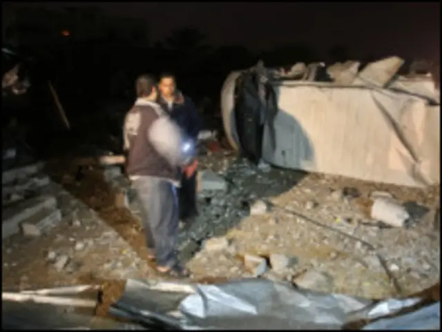 فلسطينيان يتفقدان موقعا اثر قصفه