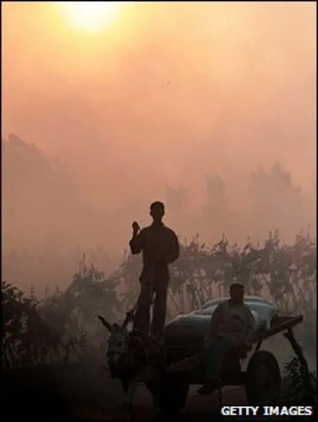 Dois homens em uma carroça envolta em fumaça