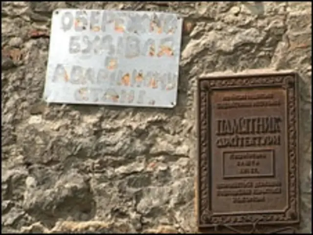 Кушнірська башта: поруч із табличкою "Пам'ятка архітектури" оголошення сповіщає про аварійний стан будівлі