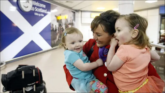 Una azafata se abraza a sus hijas