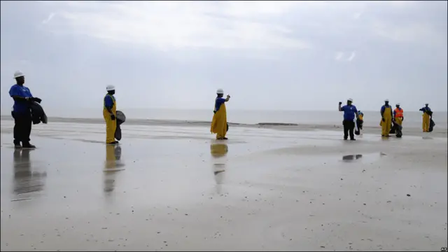 Hombres limpiando la costa
