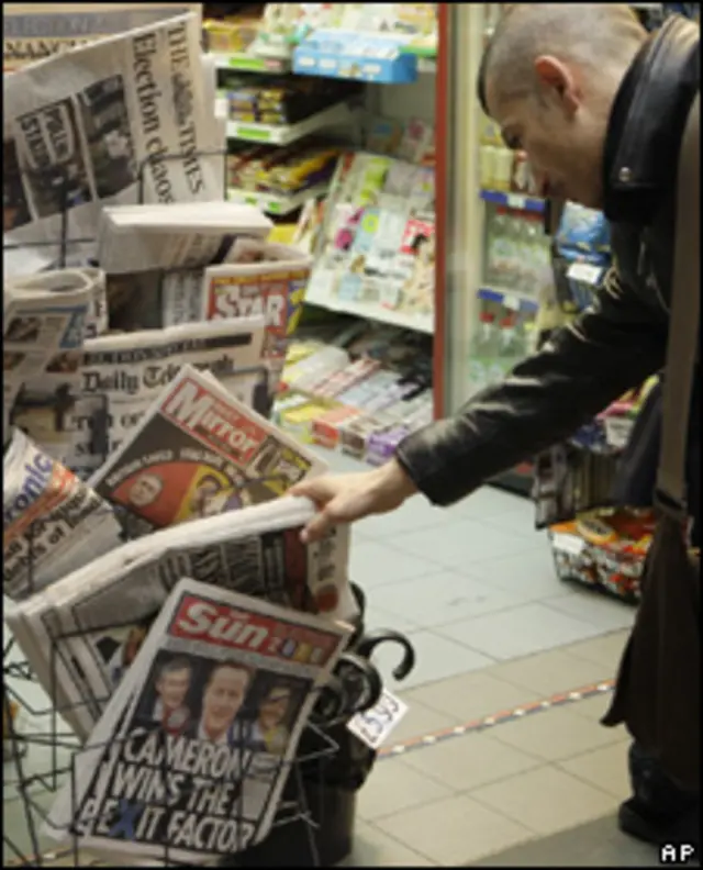 Человек выбирает газету на утро после выборов в Британии