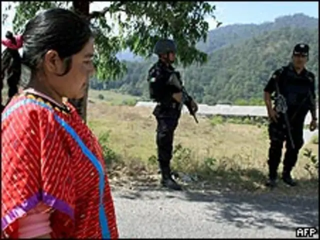 Indígena de la etnia triqui en México junto a soldado.