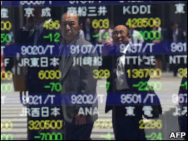 Homens observam quadro de cotações da Bolsa de Valores de Tóquio