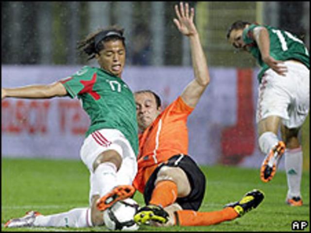 Jugador mexicano forcejeando con dos holandeses