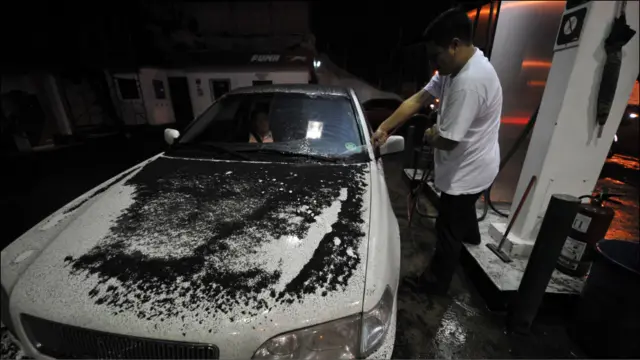 Hombre limpia las cenizas de su auto.