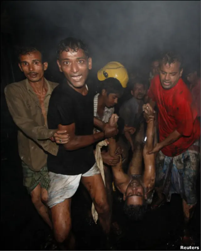 Жители Дакки выносят пострадавшего из пожара