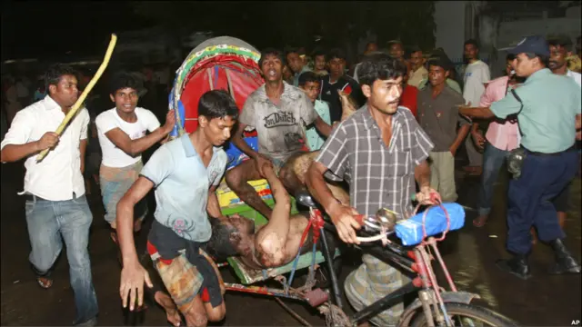 Жители Дакки везут пострадавшего в больницу
