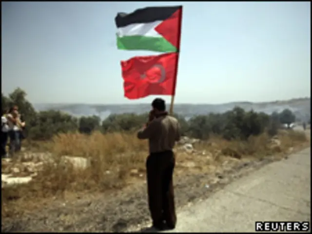 Activista palestino sostiene las banderas palestina y turca