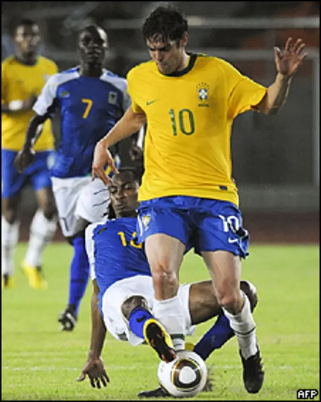 Jogador tanzaniano Nzzar tenta parar Kaká durante jogo em Dar Es Salaam