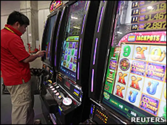 澳门亚洲国际博彩博览会上工作人员检查角子老虎机(8/6/2010)