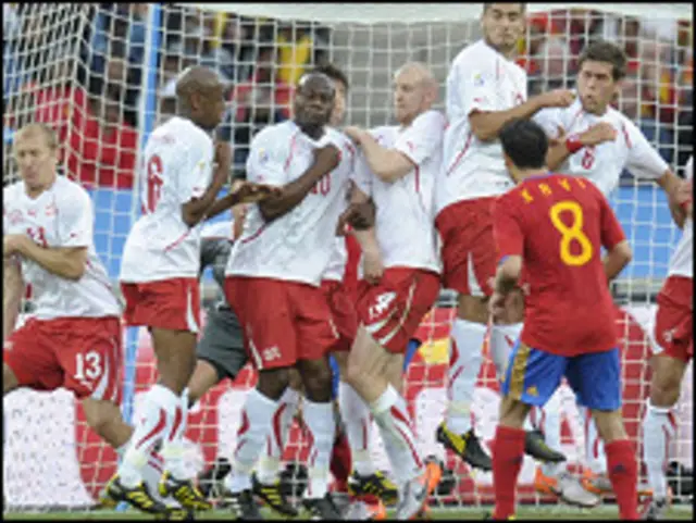 Xavi cobra un tiro libre ante la barrera Suiza