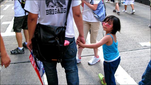 一位父亲拖着年幼的女儿参加香港“七一”游行（1/7/2010）