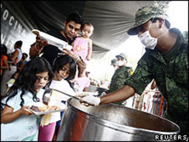 Soldado sirve comida a damnificados del huracán Alex en el barrio de Santa Catarina, en las afueras de Monterrey, México