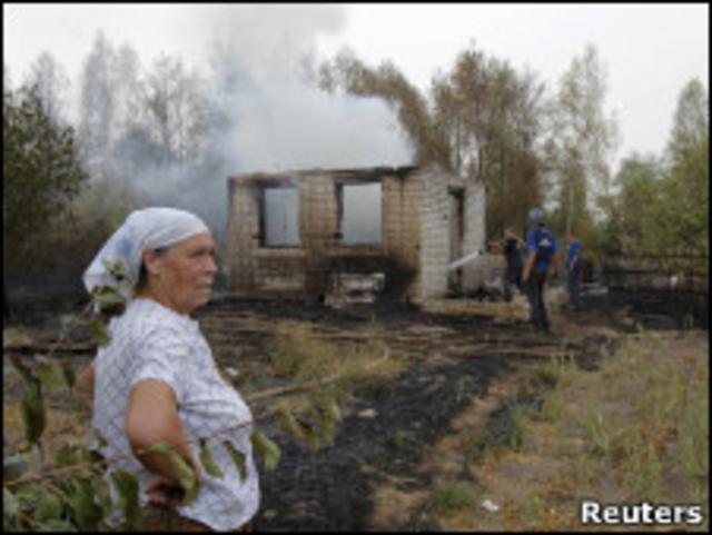 Женщина у сгоревшего дома