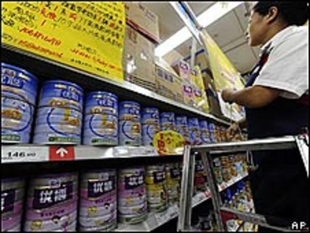 Una vendedora coloca latas de leche en polvo en un supermercado de Hefei, China.