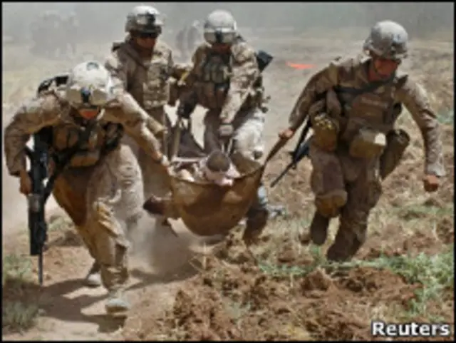 جنود من مشاة البحرية الأمريكية يبتعدون بجريح عن ميدان المعركة في أفغانستان (21/08/10)