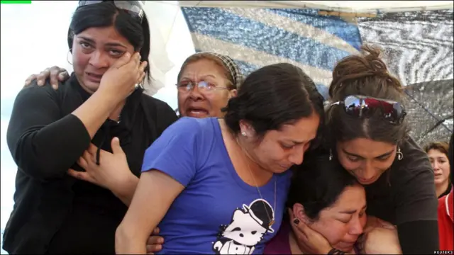 Un grupo de familiares de los mineros llora al conocer la noticia