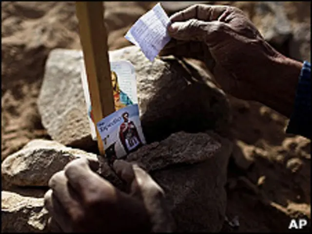 Un familiar de los mineros atrapados coloca un mensaje entre las piedras