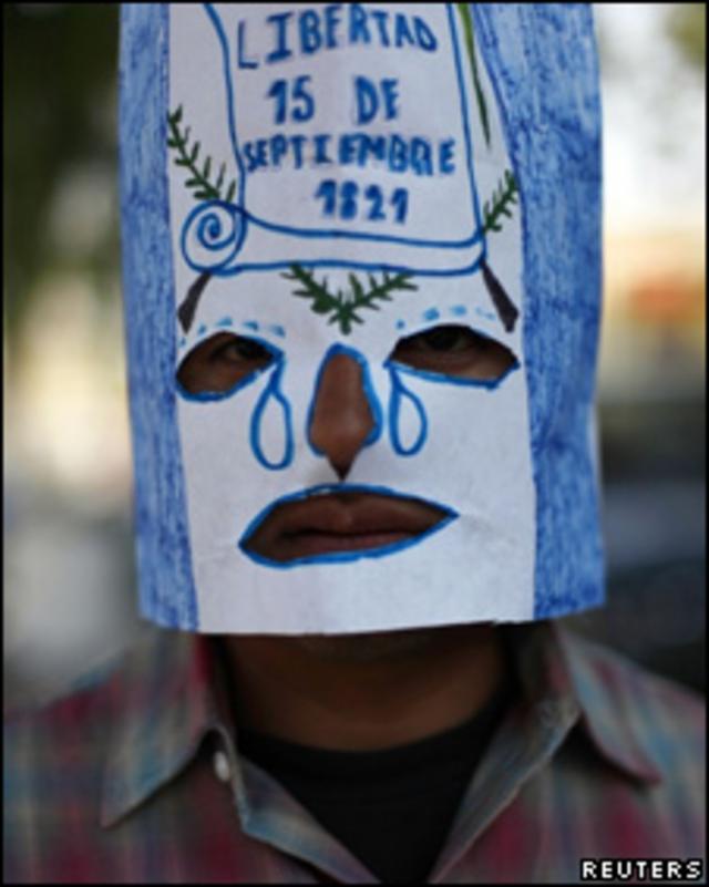 Guatemalteco se cubre la cara con los colores de la bandera de su país en señal de luto por compatriotas muertos en El Saltillo, Coahuila, México