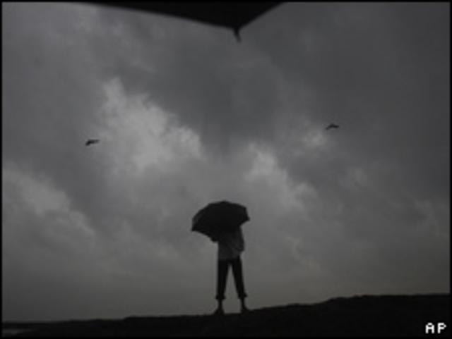 Hombre con paraguas bajo una inminente tormenta