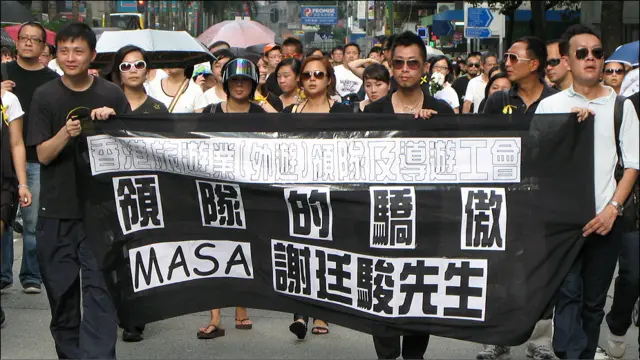 香港導遊工會人士在悼念菲律賓劫持事件死難者遊行上際打出標語悼念殉職導遊謝廷駿（29/8/2010）