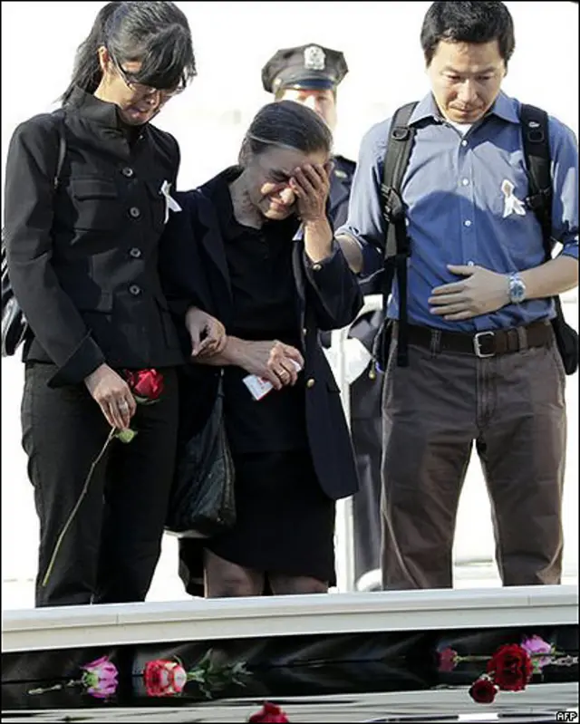 Familiares delante del monumento a las víctimas