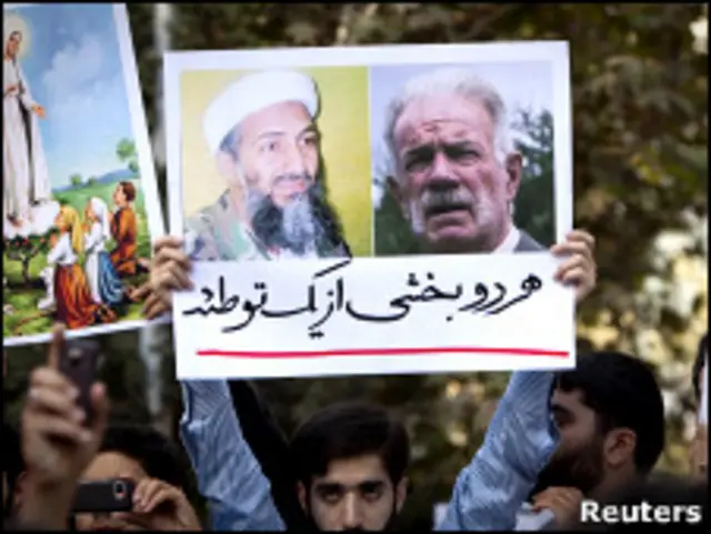 متظظاهر رفع لافتة تحمل صورة للقس الأمريكي ولزعيم القاعدة كتب تحتها: "وجهان لمؤامرة واحدة"