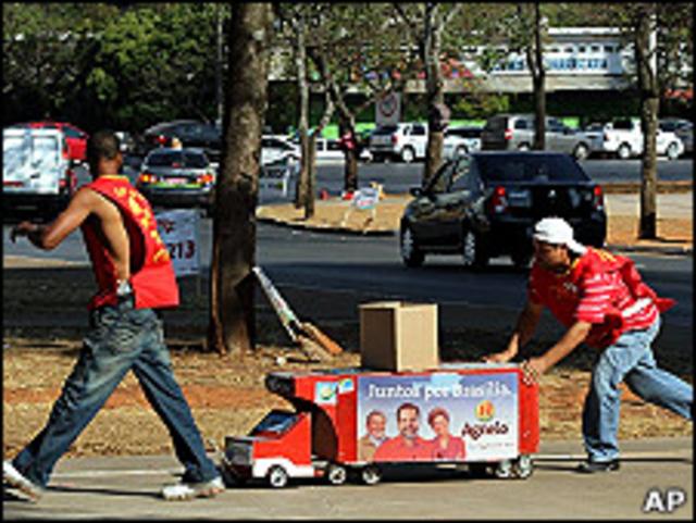 Dos hombres tiran de un carro con propaganda electoral